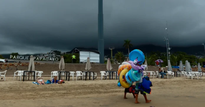 Vendedores caminan en una playa de Acapulco, Guerrero, durante la temporada de huracanes. Foto: EFE/Archivo