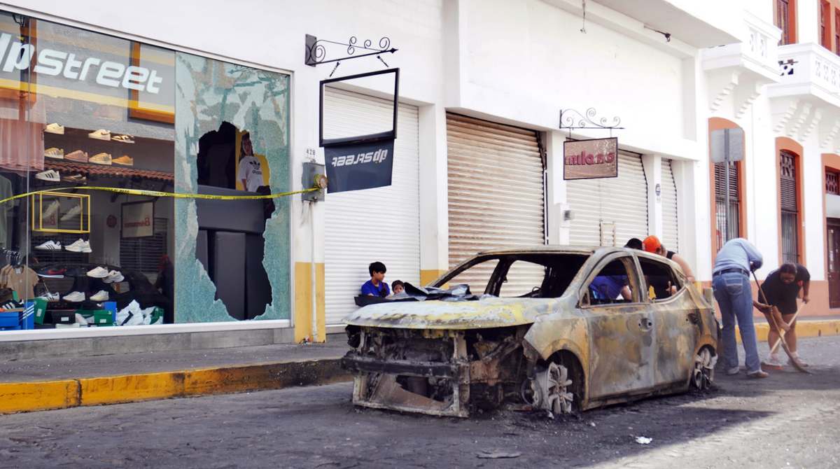 Personas limpian una de las calles en donde fue incendiado un automóvil, en la ciudad de Puerto Vallarta, tras el operativo en contra de ‘El Mencho’. Foto: EFE/Arturo Montero Personas limpian una de las calles en donde fue incendiado un automóvil, en la ciudad de Puerto Vallarta, tras el operativo en contra de ‘El Mencho’. Foto: EFE/Arturo Montero
