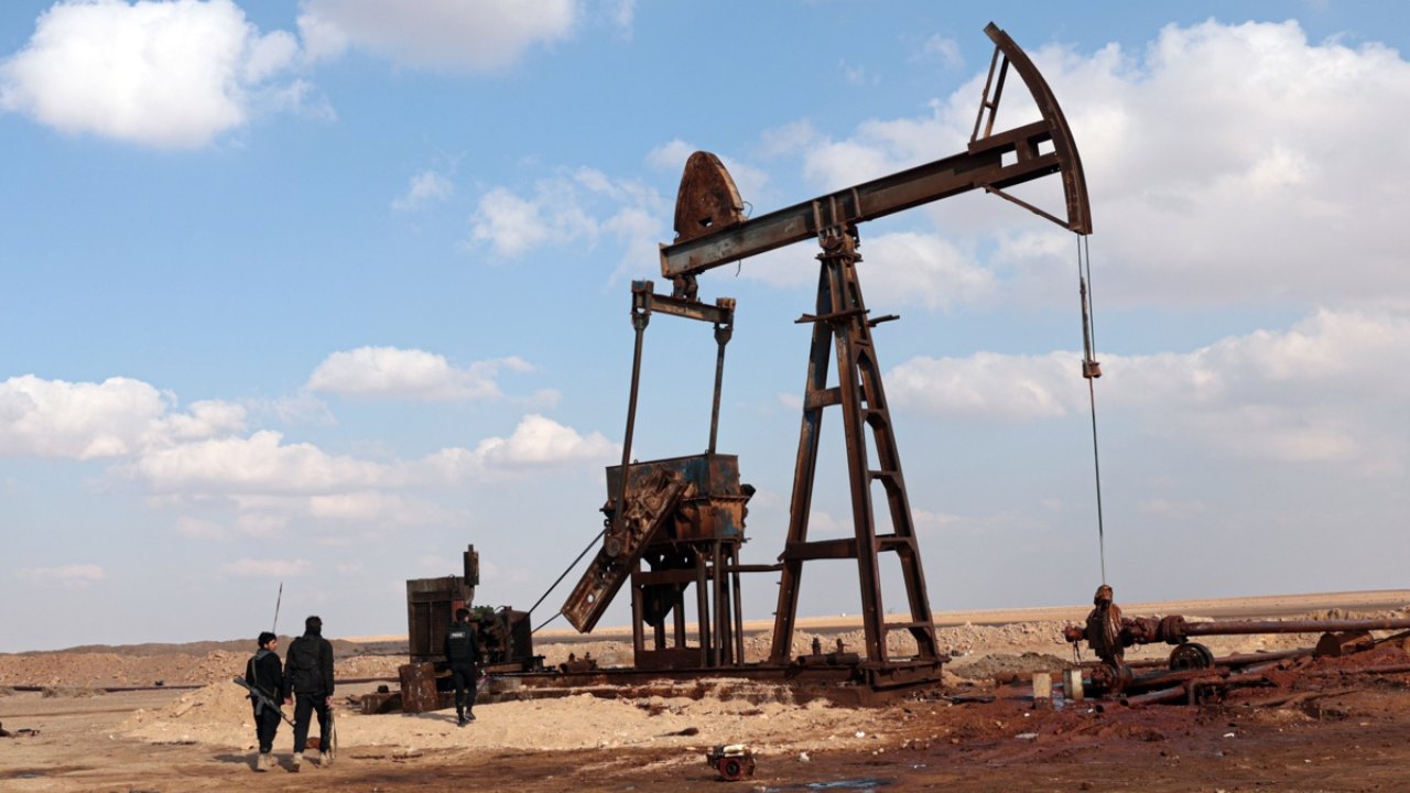 Funcionarios sirios se encuentran frente a uno de los pozos de petróleo en el campo petrolífero de Al-Omar. Foto: EFE/EPA/Mohammed Al-Rifai