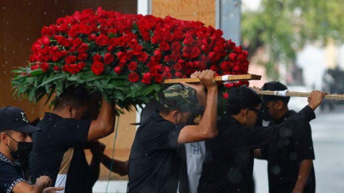 Personas cargan un arreglo floral durante la velación de Nemesio Oceguera Cervantes, alias ‘El Mencho’, en Guadalajara. Foto: EFE/Francisco Guasco