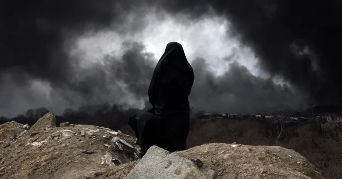 Una mujer iraní con velo observa mientras el humo sigue elevándose desde la refinería de petróleo de Shahran atacada en Teherán. Foto: EFE/EPA/Abedin Taherkenareh