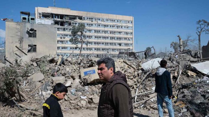 Varias personas caminan cerca de una zona alcanzada por los bombardeos israelíes-estadounidenses en los alrededores del Gran bazar de Teherán. Foto: EFE/Jaime León